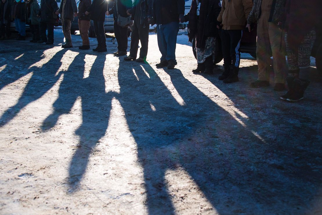 Native Americans and activists protesting against the Dakota Access pipeline hold hands during a prayer circle at the Oceti Sakowin Camp on the edge of the Standing Rock Sioux Reservation on December 4, 2016 outside Cannon Ball, North Dakota.